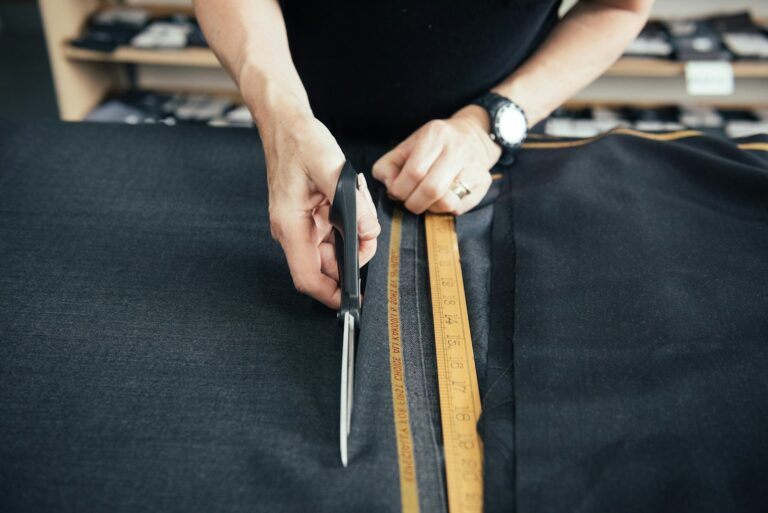 a person cutting a piece of fabric with a pair of scissors